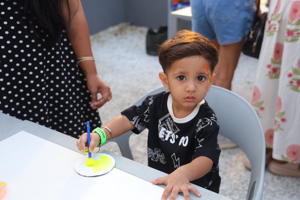 Young child painting with neon colors in play zone